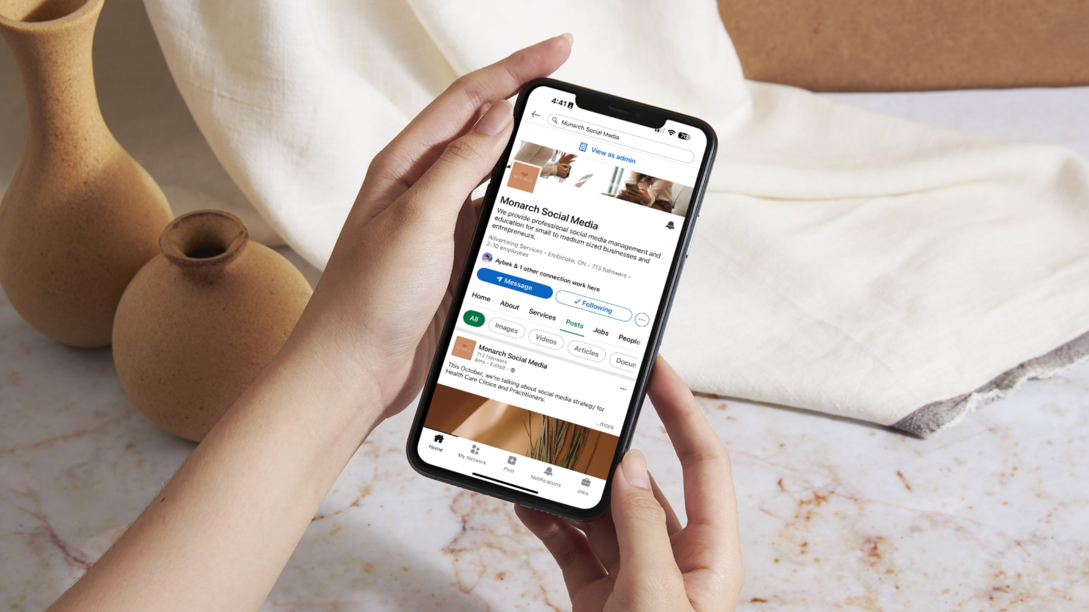 Monark Wild Rice LinkedIn Optimization The LinkedIn business page for Monarch Social Media is open on a phone screen, showing a professional banner, services listed, and a benefit-focused company description.