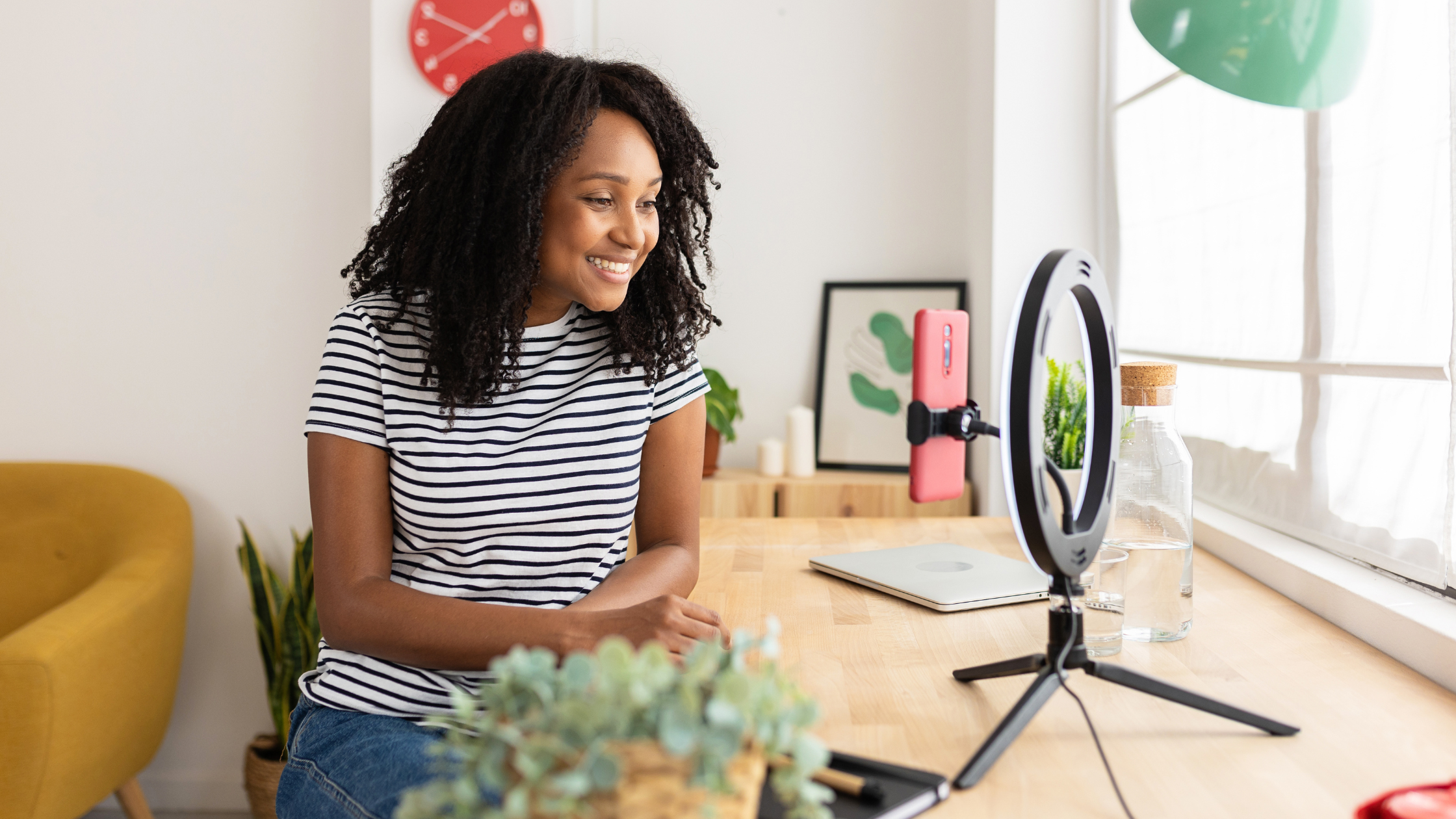 Content Creator Using Ring Light for Video Shoot at Home Female content creator recording video with smartphone and ring light in a bright home office