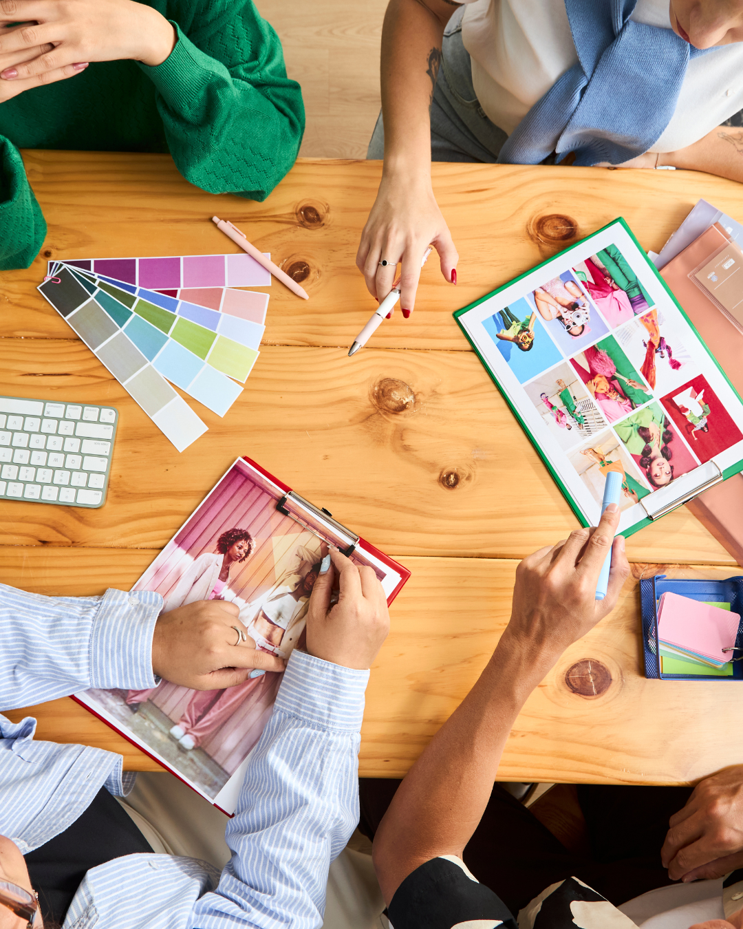 Diverse creative team collaborating over brand color palettes and visual concepts at a wooden table
