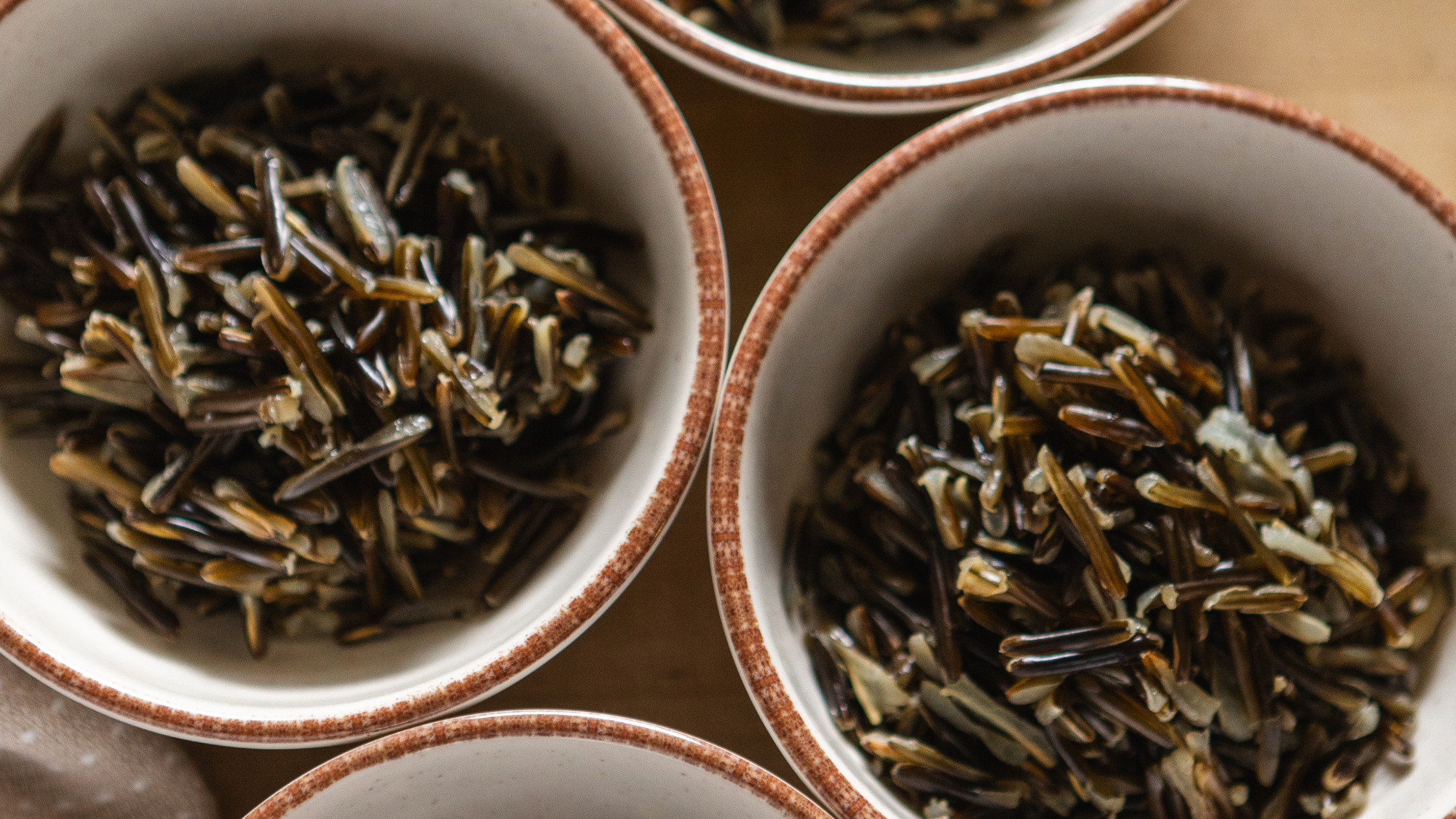 Close-up of cooked wild rice in ceramic bowls with rustic brown rims