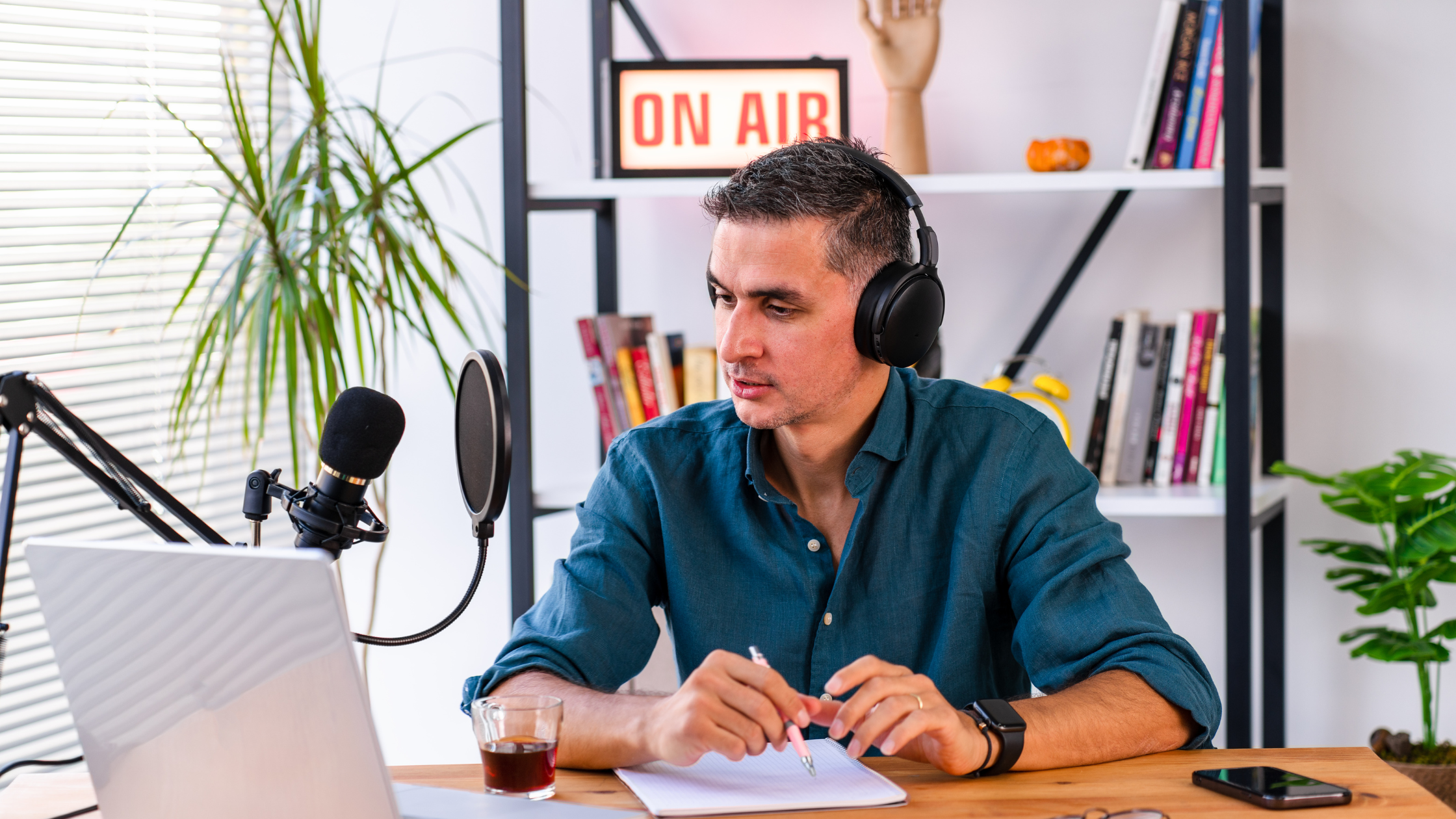 Man recording content with a microphone and headphones during a podcast-style online session.