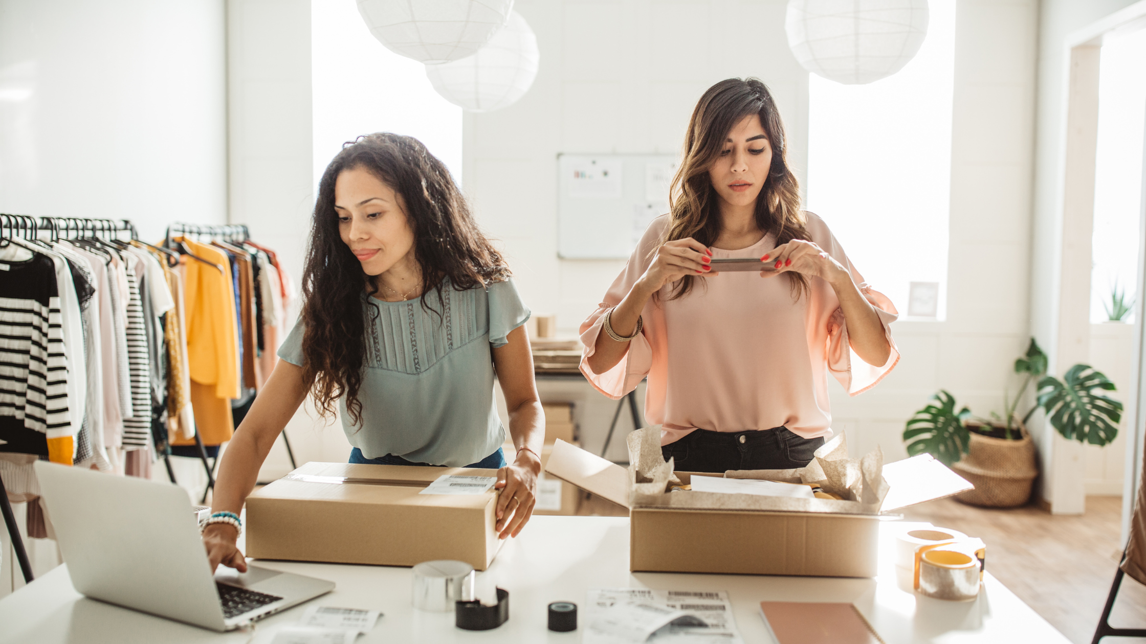 Two small business owners packing products in a studio, representing social media supporting e-commerce growth