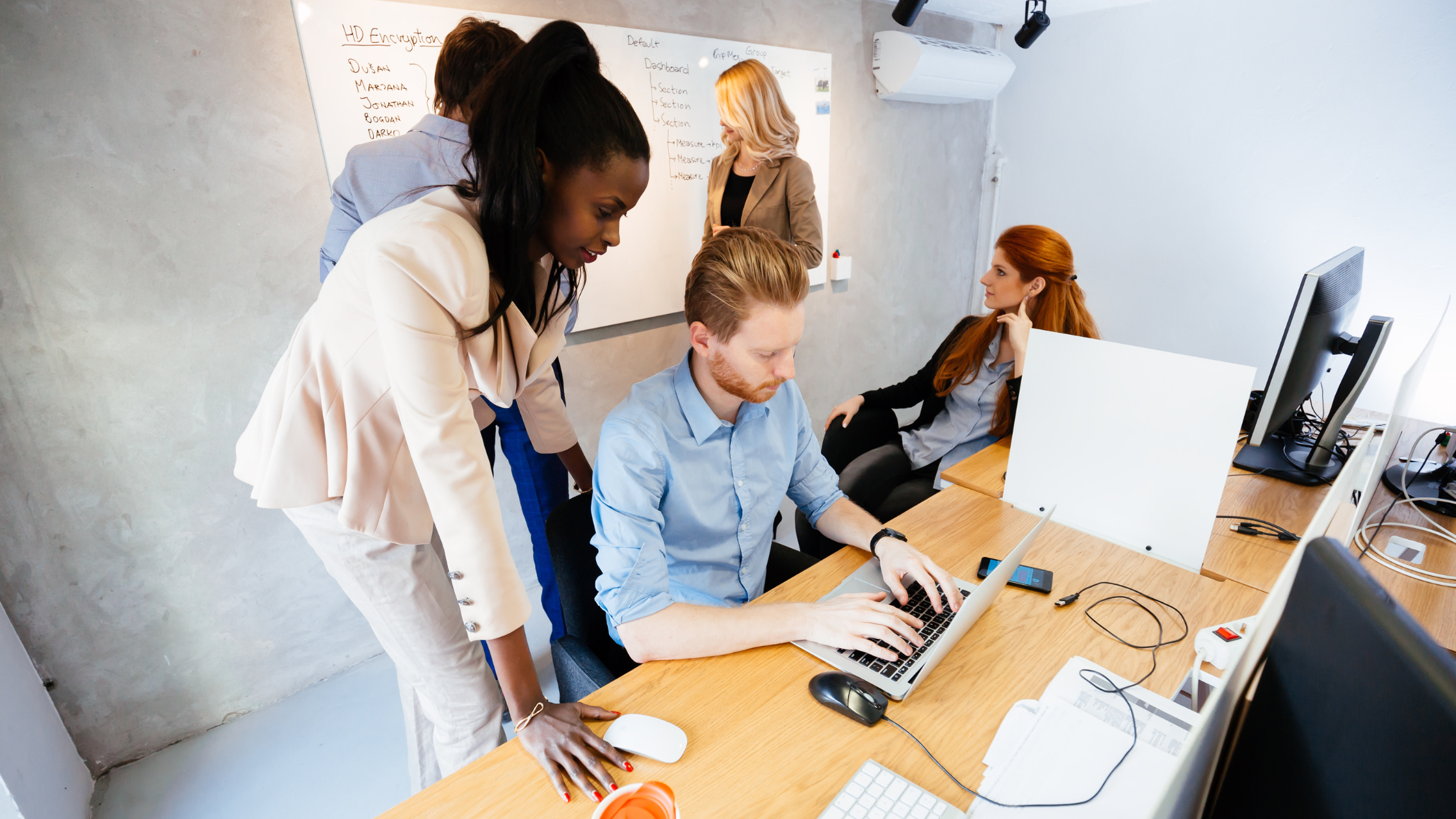 A diverse team collaborating around a workspace, reviewing strategy together.