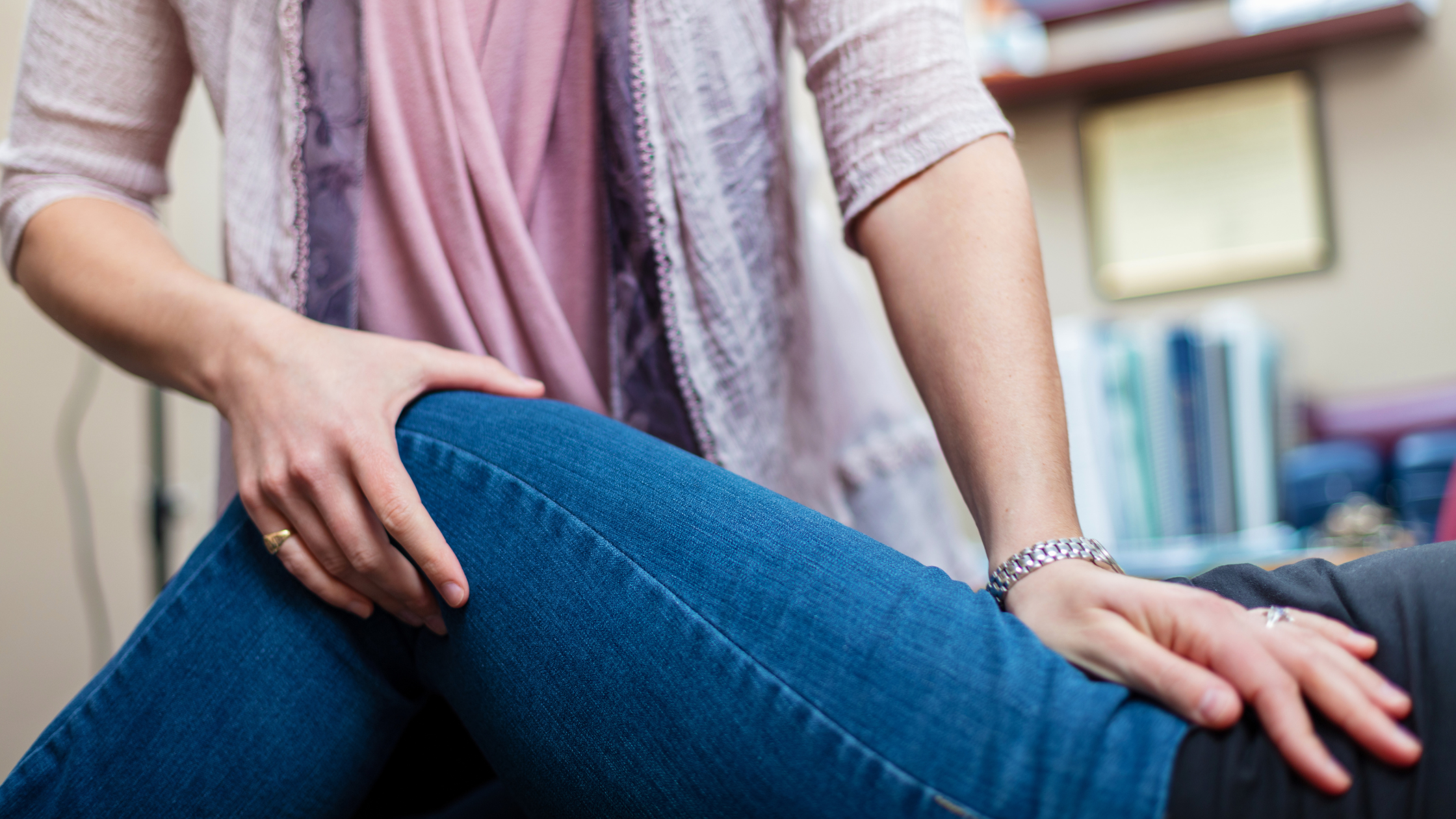 Manual therapist supporting a patient’s knee during hands-on treatment