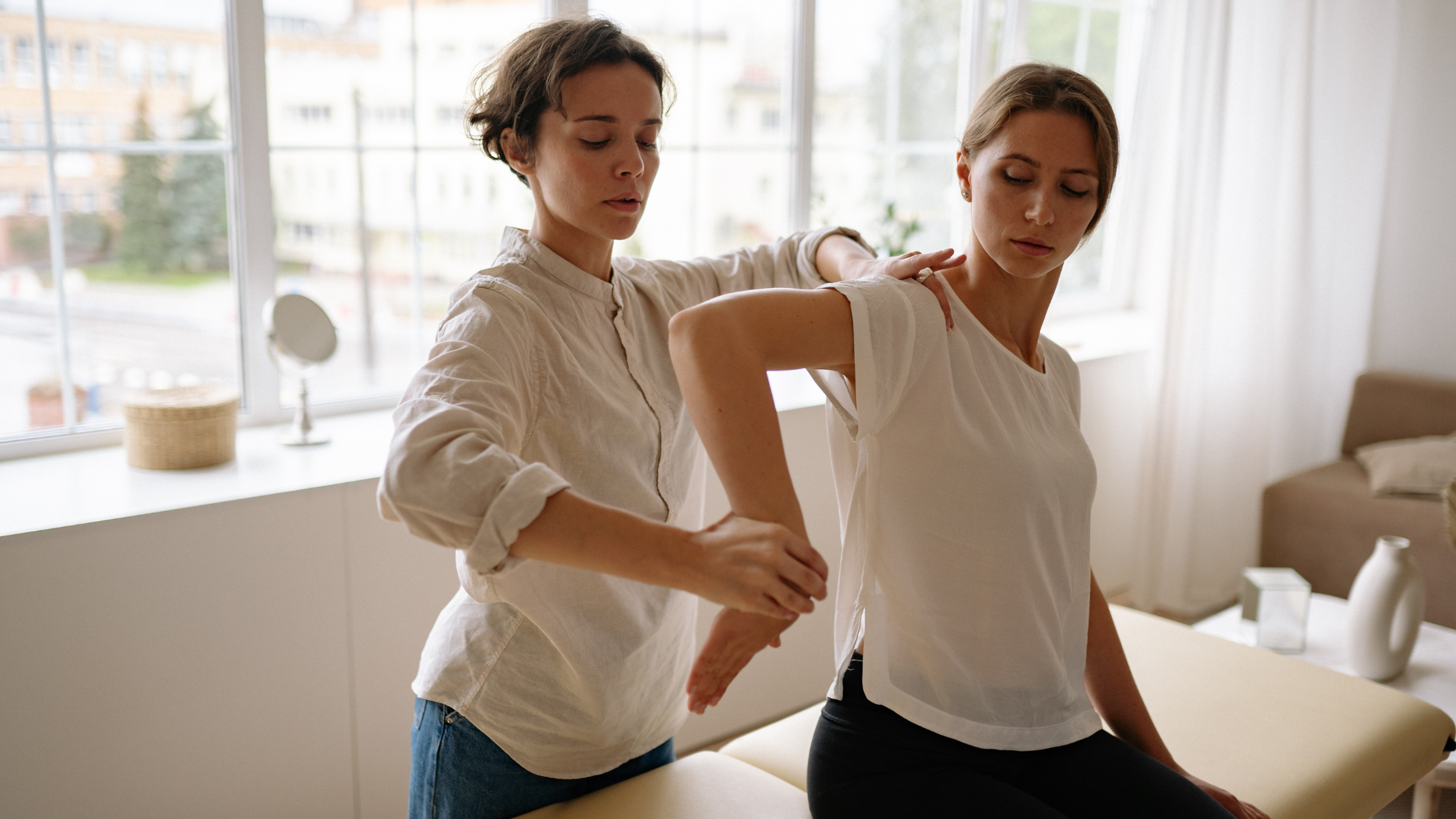Practitioner assessing shoulder mobility during physiotherapy appointment