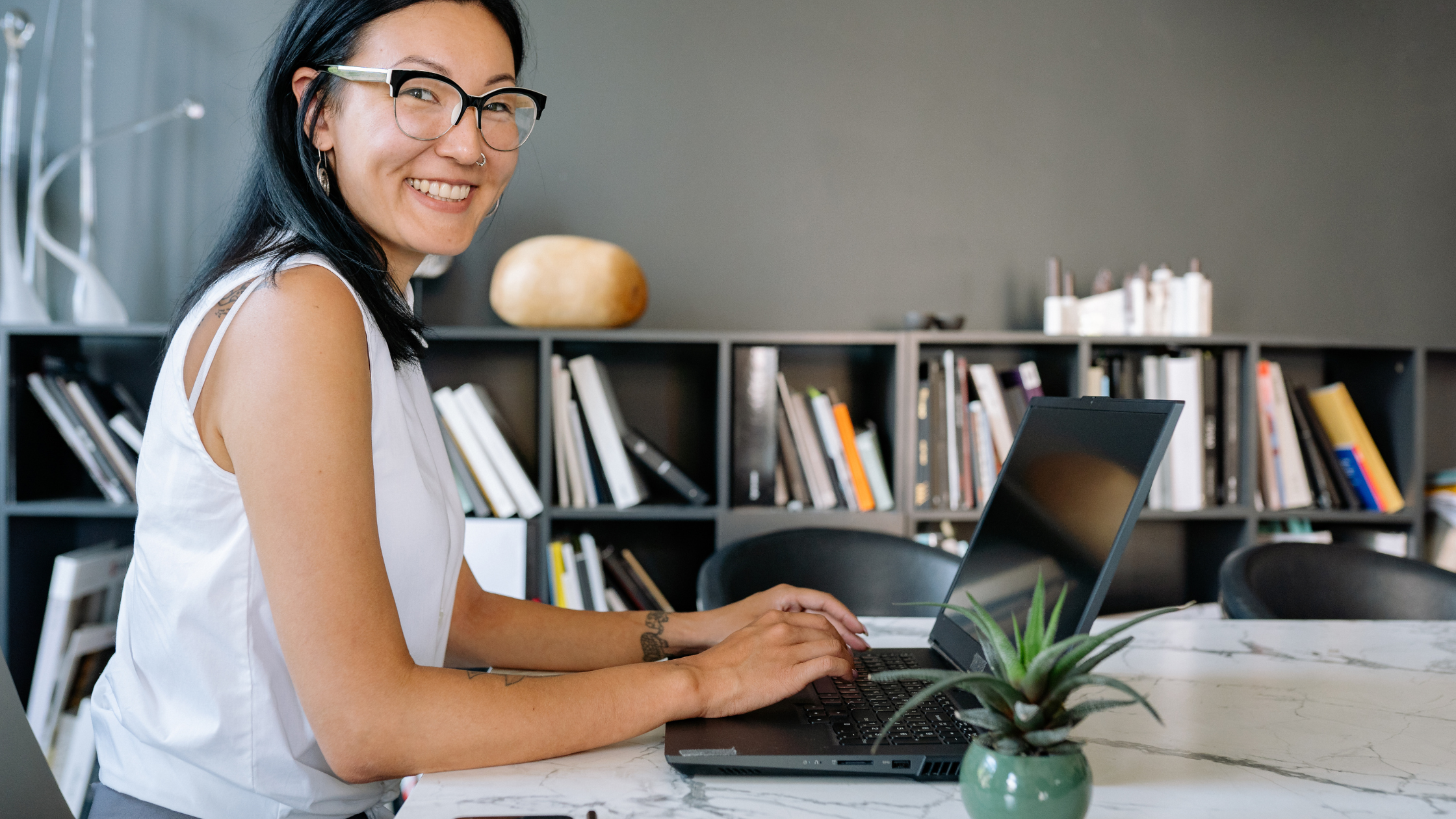 Smiling female executive working on a laptop in a modern office workspace