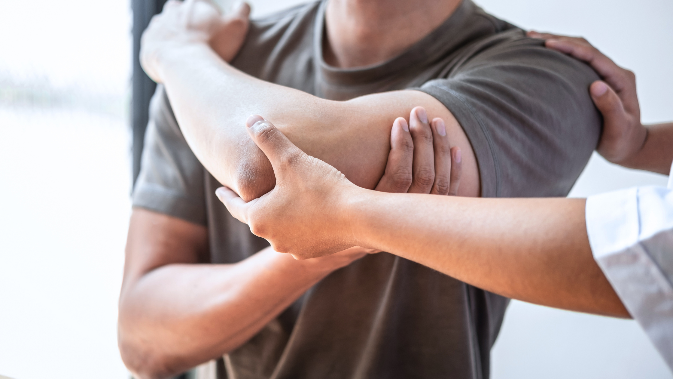 Physiotherapist examining patient’s elbow for pain and mobility issues