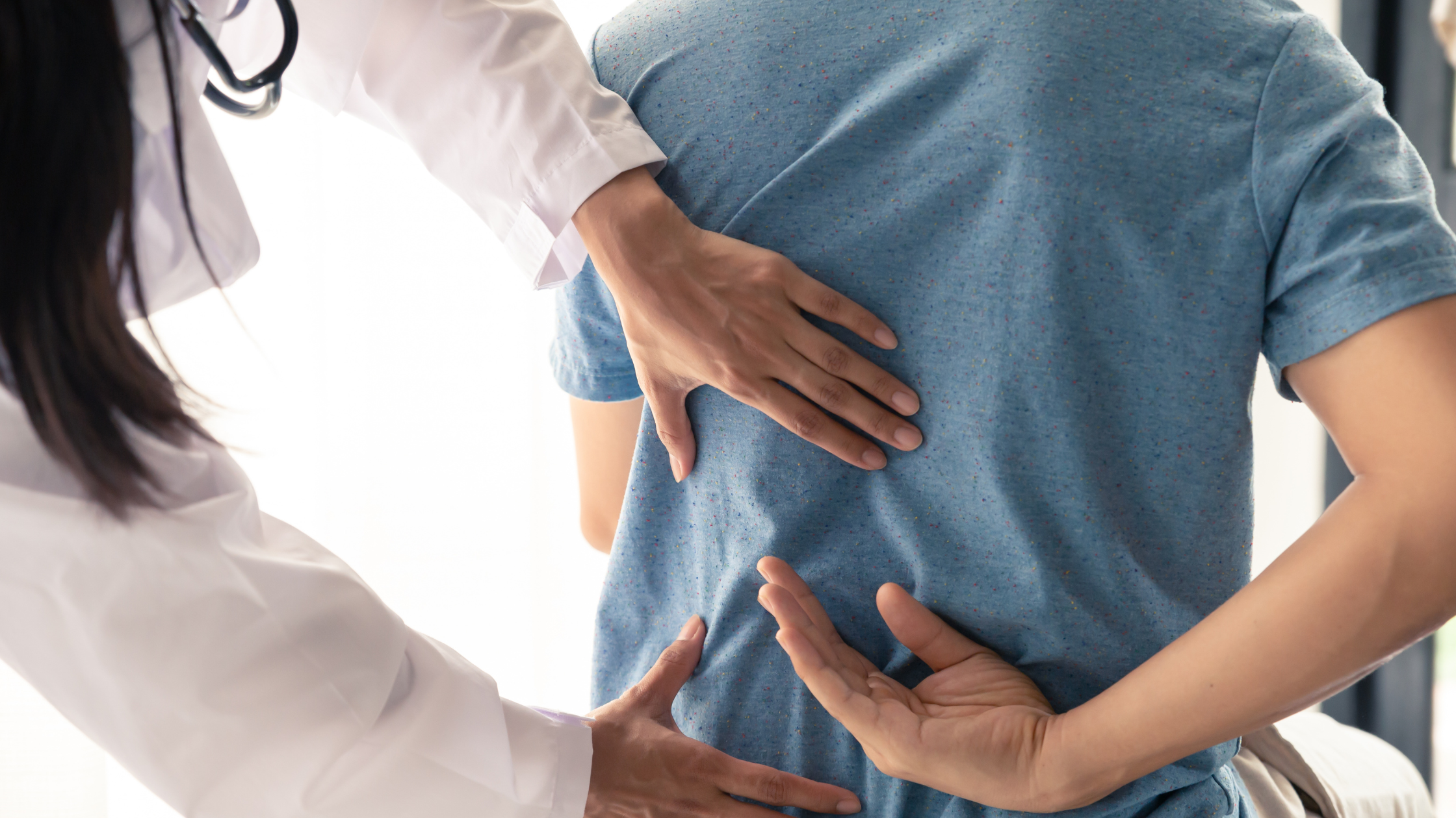 Healthcare professional assessing patient’s lower back for pain and posture issues