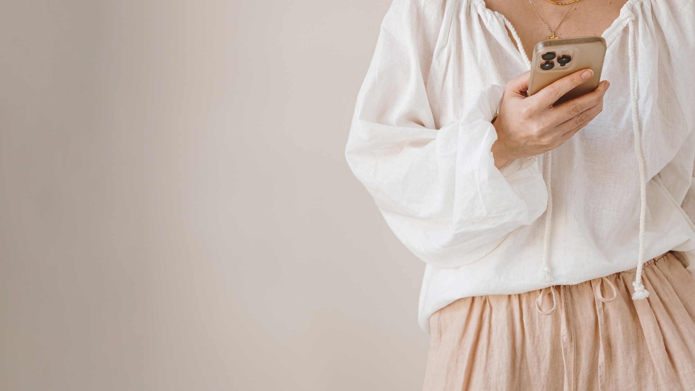 Woman using smartphone for social media browsing in a minimal neutral setting