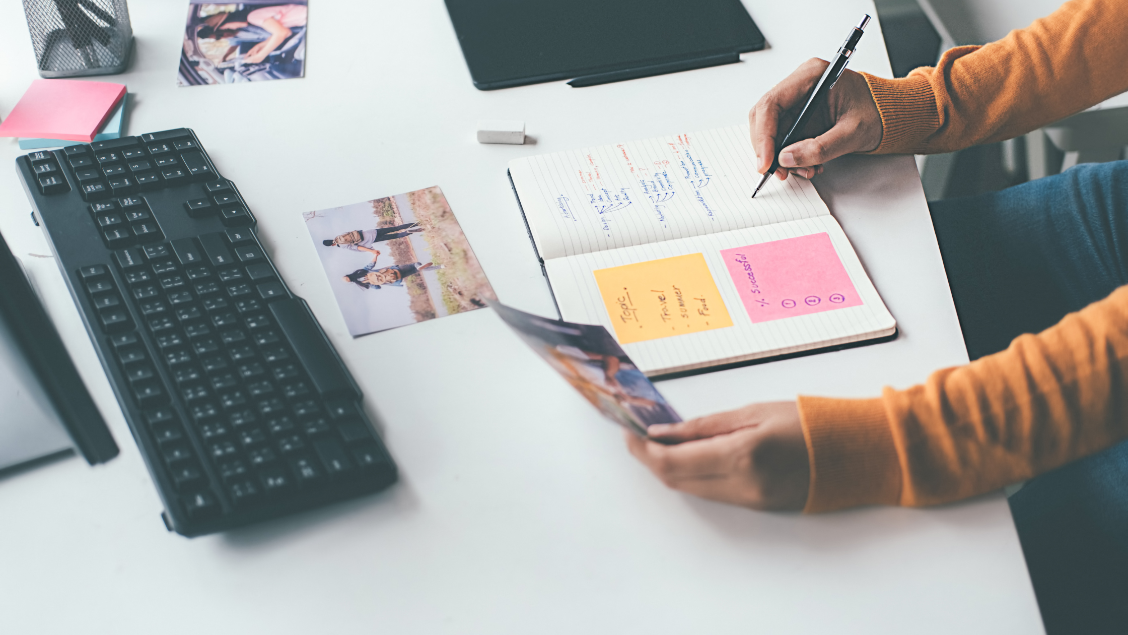 Content creator planning a product seeding campaign with influencer photos, sticky notes, and a strategy notebook