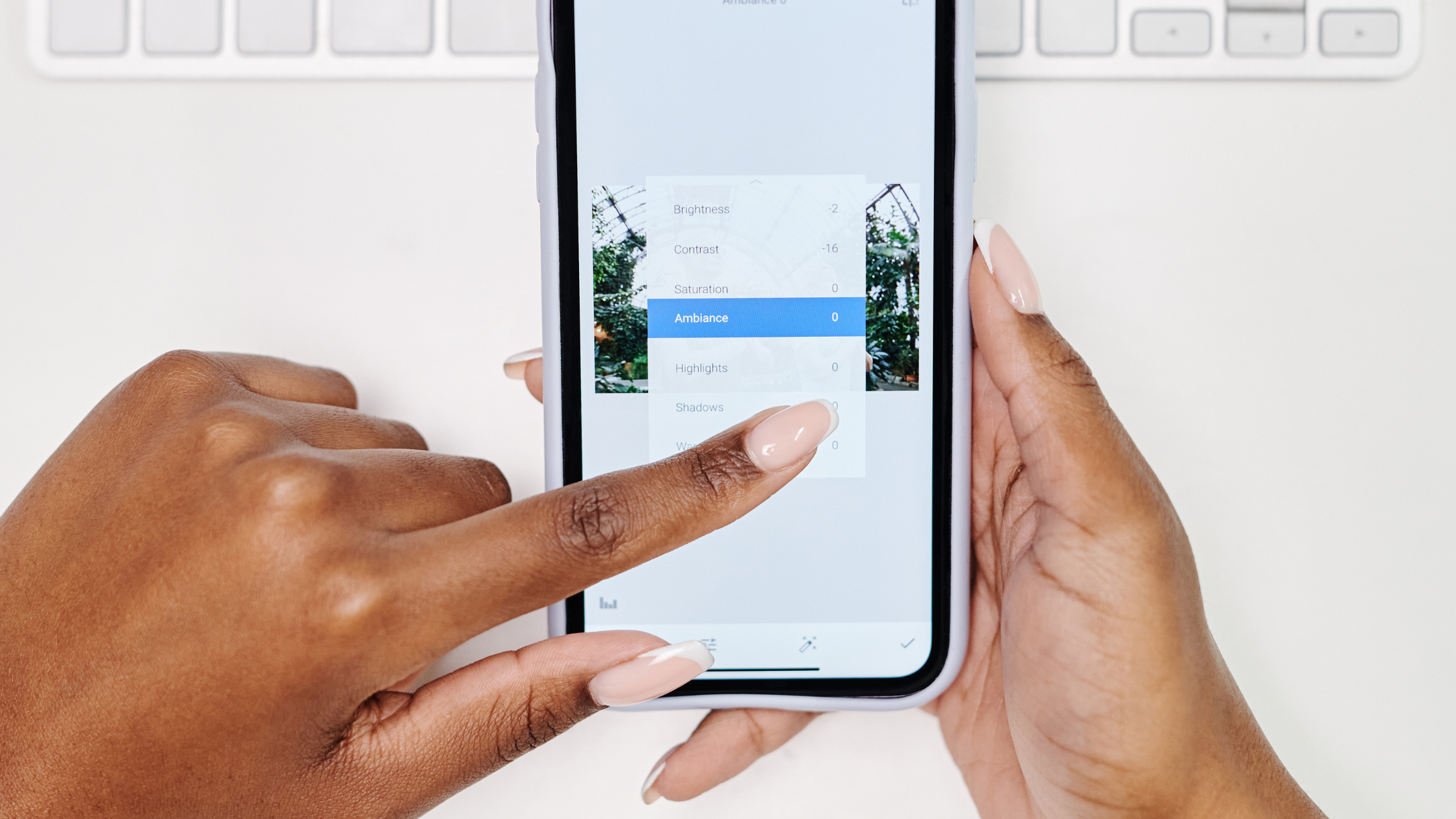 Hands adjusting brightness and contrast settings while editing UGC content on a smartphone