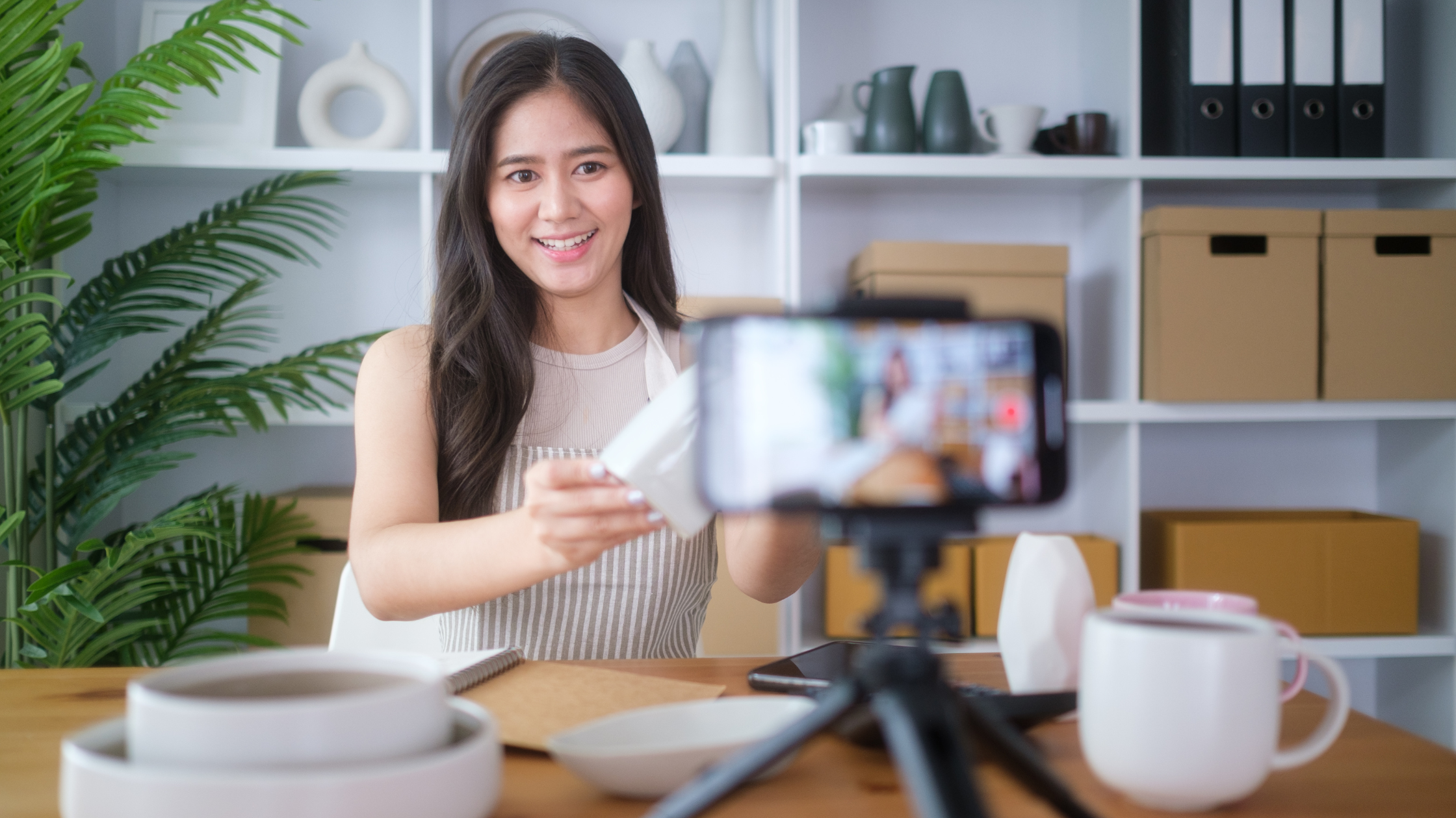 Creator filming an unboxing video of a seeded product on her phone