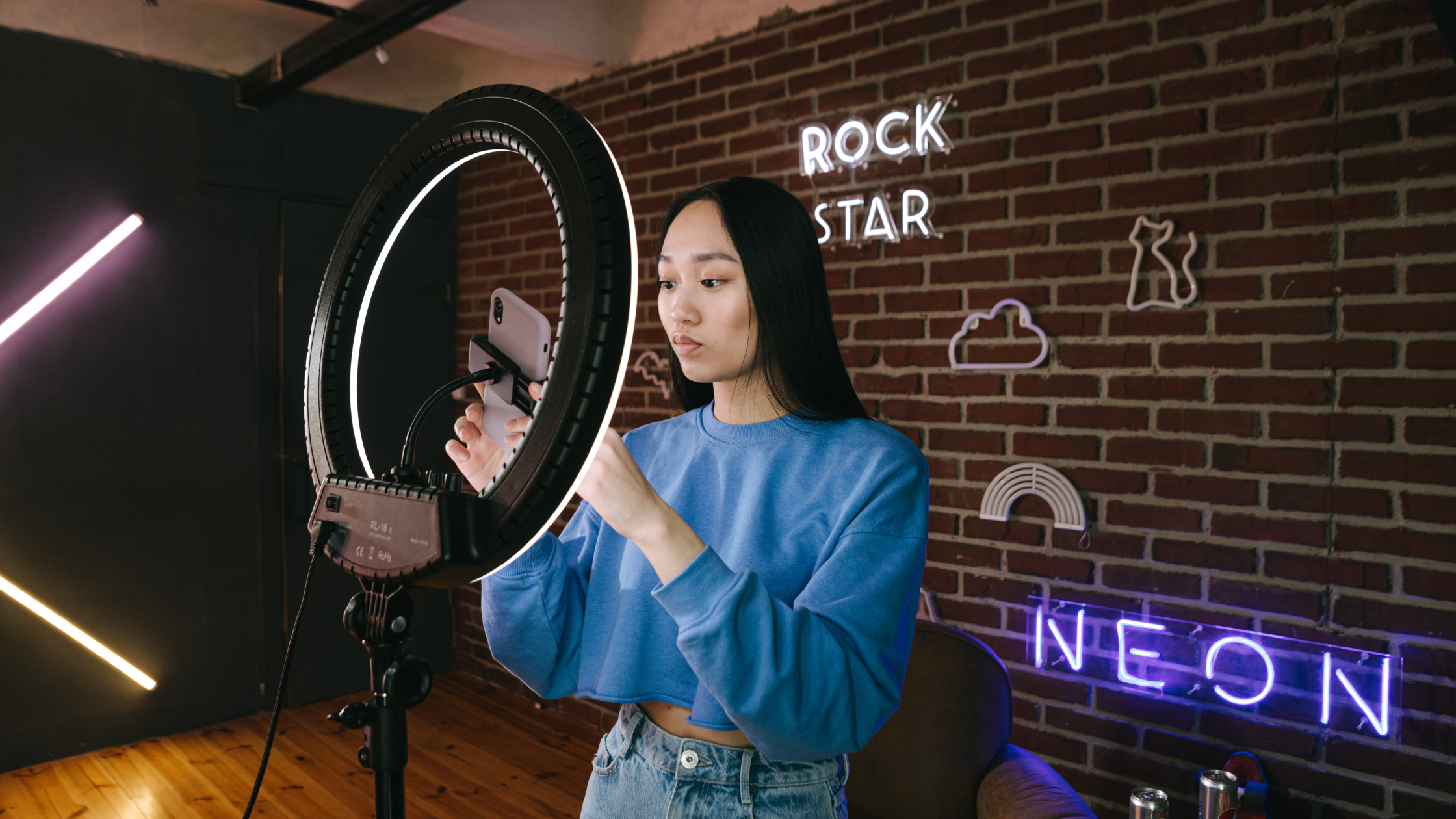 Content creator setting up phone on ring light to film organic TikTok video for Spark Ads