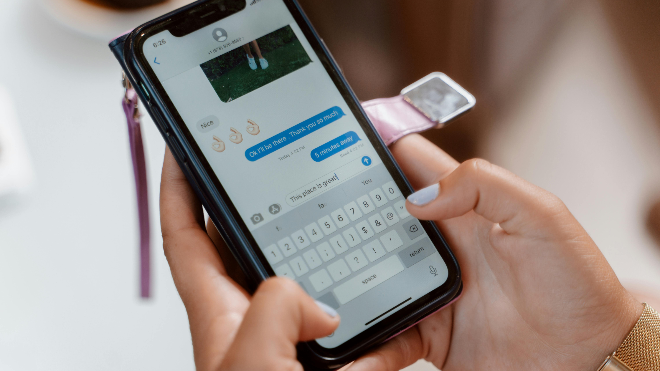 Hand holding a phone showing a text conversation with a reply already typed, an example of community management on social media