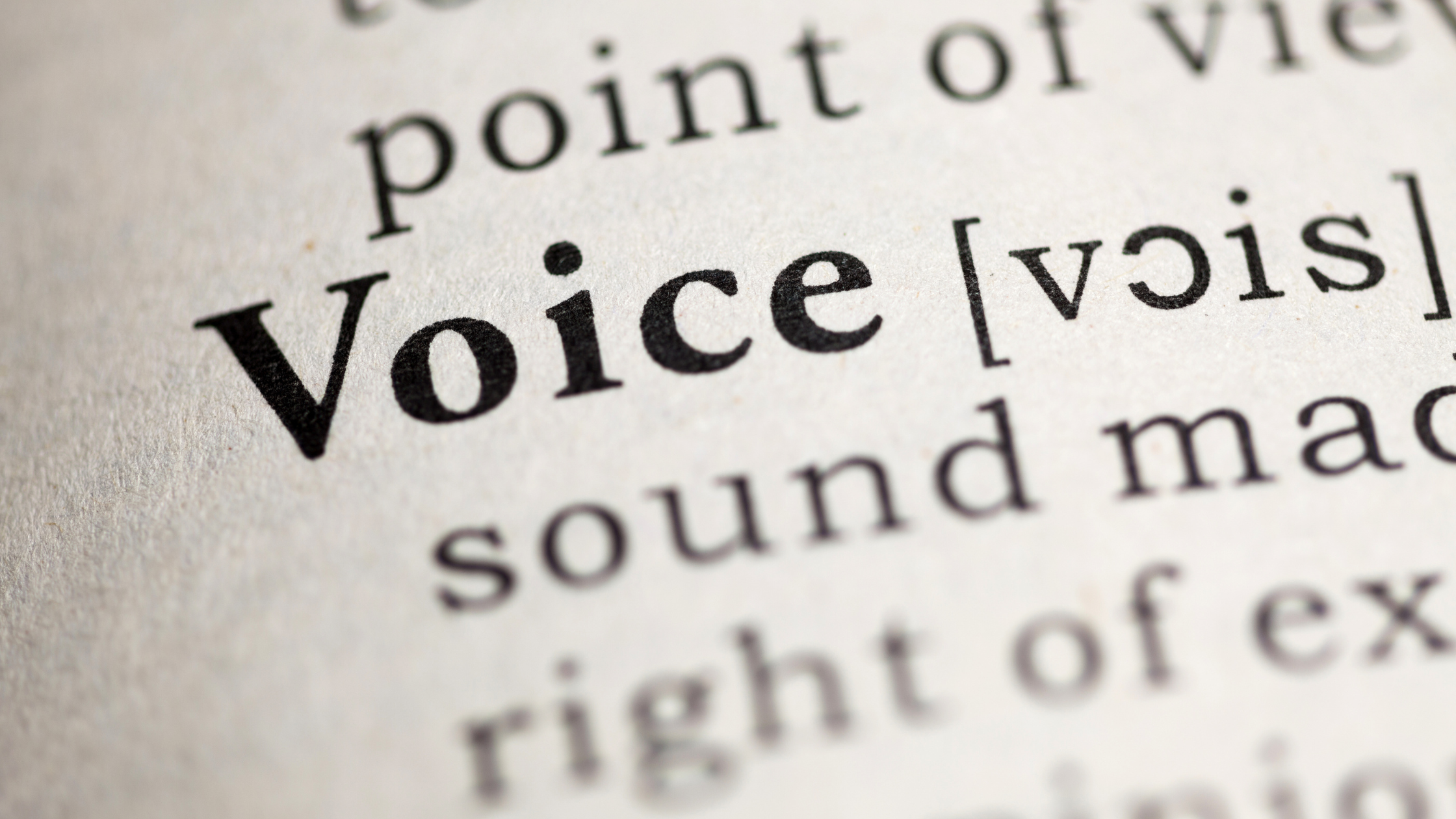 Dictionary page with the word "Voice" defined in close up, representing brand voice in community management