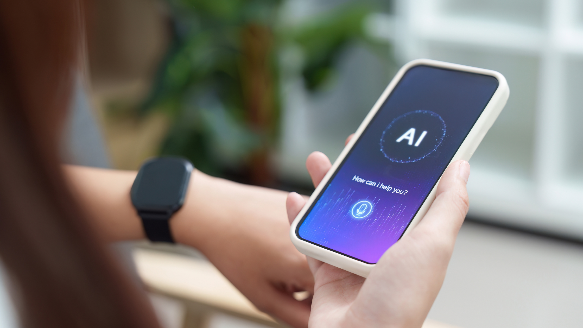 Hand holding a phone displaying an AI voice assistant interface, representing how clients and talent now find agencies through AI