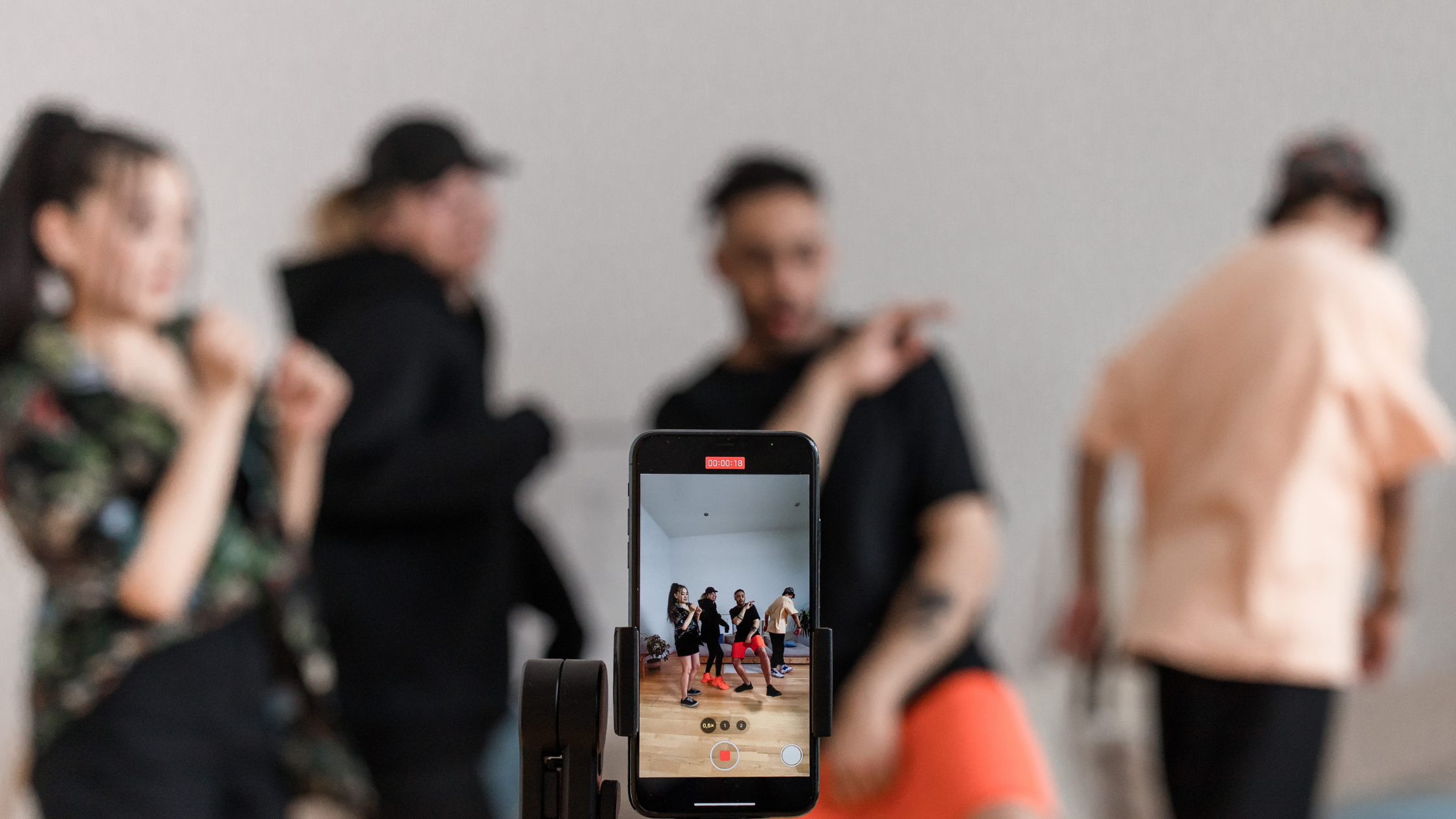 Smartphone on a tripod recording a group of four people dancing, representing UGC creators filming authentic social content