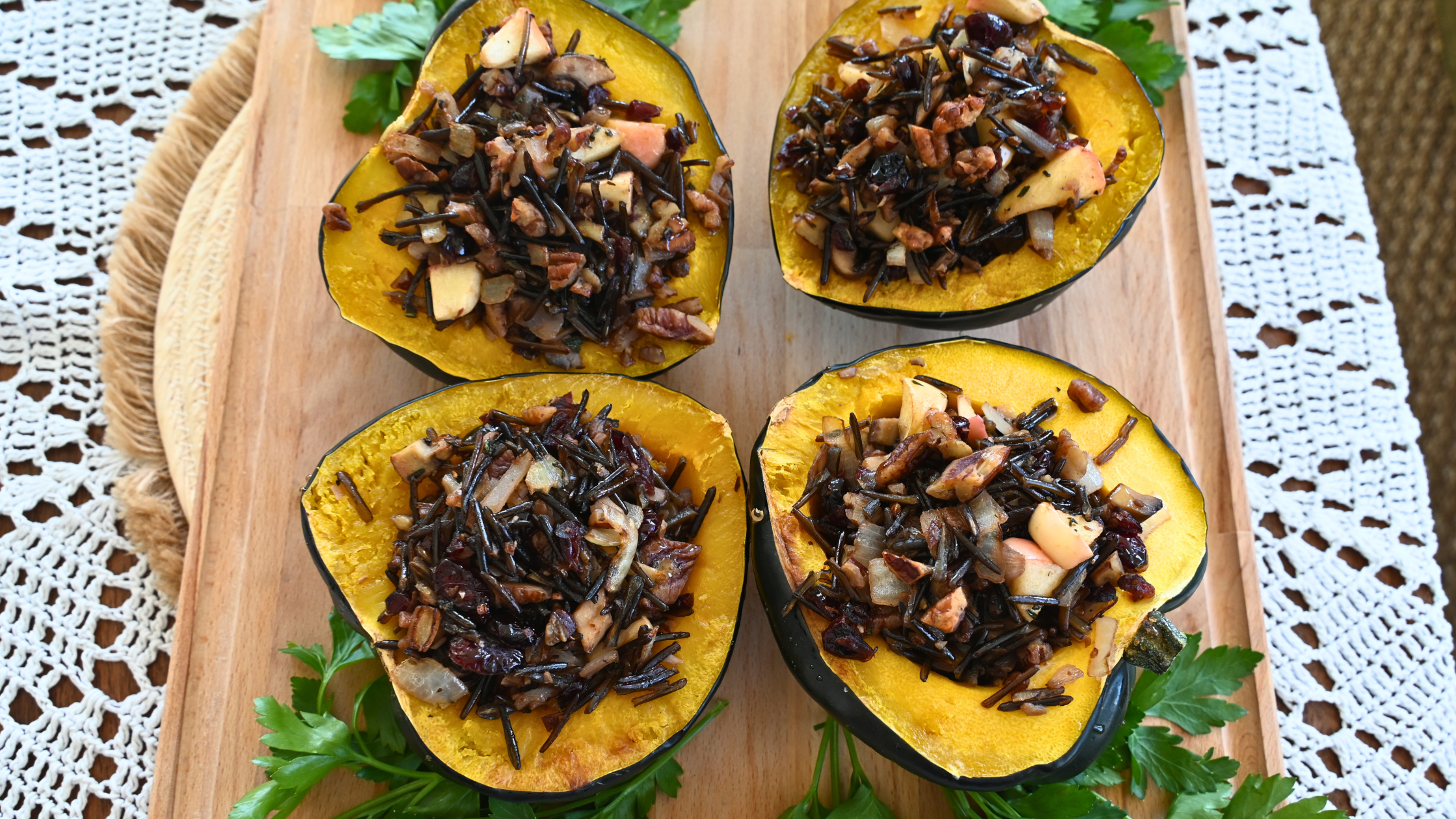 Roasted acorn squash halves stuffed with wild rice, cranberries, pecans and apple on a wooden board, a Monark Wild Rice dish