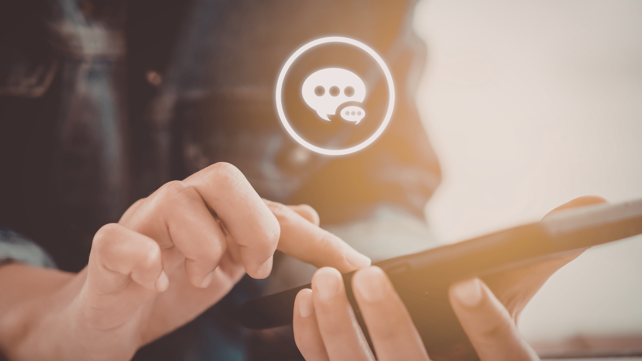 Hand tapping a smartphone screen with a glowing chat bubble icon above it, representing direct messages on social media